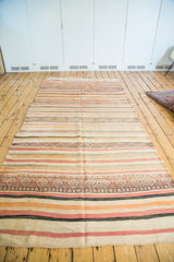 Vintage tribal kilim runner with geometric stripes in ivory, orange, red, and charcoal.