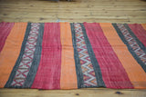 Alternating red, orange, and charcoal stripes with geometric serrated patterns on vintage kilim runner.