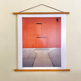 Joe Farrell 'Three Doors' photograph in wooden magnetic hanger on a light wall.