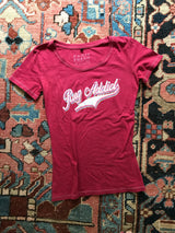 Watermelon red scoop neck tee with retro 'Rug Addict' script and contrast stitching.