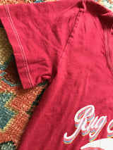 White contrast stitching detail on the sleeve of a soft watermelon red t-shirt.