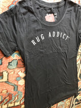 Charcoal scoop neck t-shirt with white arched 'Rug Addict' text and contrast stitching.