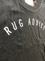 White contrast stitching on the neckline of a charcoal t-shirt with 'Rug Addict' text.