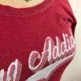 Angled view of the red scoop neck tee's contrast stitching and retro lettering.