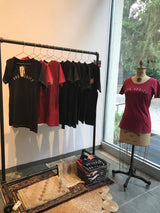 Showroom display of red and black Rug Addict t-shirts with small vintage rugs.