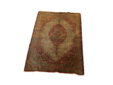 Angled view of a rare Haji Jalili silk Tabriz mat, showcasing its intricate medallion and aged patina.