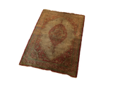 Angled view of a rare antique silk Tabriz rug, highlighting its complete medallion design and aged character.
