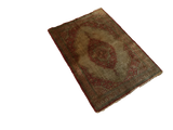Angled perspective of an antique silk Tabriz rug, showing its rust medallion and time-softened ivory field.