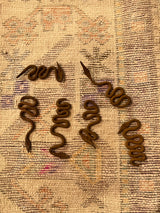 The full batch of available one-of-a-kind vintage twisty iron snake figures.