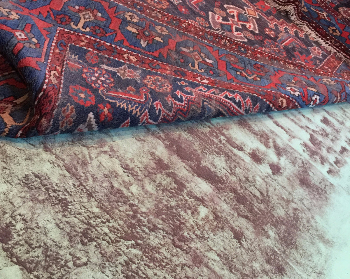 Professional cleaning in progress for a hand-knotted rug, showing the removal of deep dirt and stains.