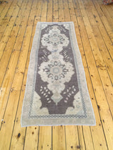 Soft pile of the vintage Oushak runner featuring geometric border and faded motifs.