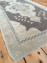 Softened, faded tones and geometric border pattern on a vintage Oushak runner.