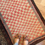 Textured peach and cream stepped checkerboard pattern on a vintage 1960s Tulu rug.