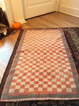 Vintage Tulu rug corner with salmon, ivory stepped pattern, grey border, and fringe.