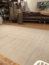 Beige and grey herringbone pattern on a reversible flat woven rug.
