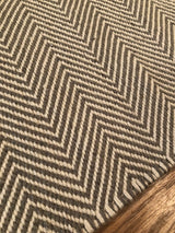 Handmade gray and off-white chevron pattern on a woven Dawn Collection rug.