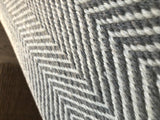 Close-up of a modern geometric gray and off-white chevron pattern on a hand-woven carpet.