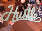 Hustle Sign Aqua plywood decor, hand painted in flowing script, 32 inches wide.