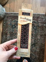 Freud Rug Bookmark with miniature Qashqa'i geometric pattern in black, red, white, and blue.
