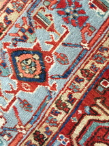 Hand-knotted Heriz rug detail with geometric motifs in sky blue, cherry red, navy, and ivory.