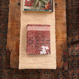 Old New House Rug Coloring Book styled on a rustic wood coffee table with a woven runner.