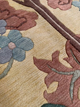 Plush pile detail of Arts and Crafts inspired floral motifs in dusty green and raspberry.
