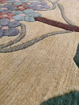 Plush hand-knotted pile defining arts and crafts floral motif in beige, green, raspberry.