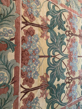 Indian William Morris design detail with dusty green leaves, faded raspberry, and soft blue blossoms.