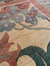 Plush William Morris design rug showing beige, dusty ocean green, faded raspberry floral patterns.
