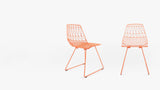 Two Modern Lucy side chairs in copper, showing side-rear and front views.