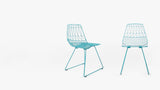 Turquoise wireframe Lucy side chair with geometric back and angled legs.