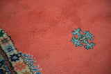 Plush blush red pile and colorful geometric details on the vintage Moroccan carpet.