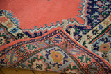Vintage Moroccan carpet corner: thick blush red pile, geometric border, and braided fringe.
