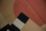 Flatweave contemporary Kilim rug corner in madder root red, sand, black, and beige.
