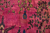 A blue vase motif with sprawling floral vines on the time-softened magenta pile of a vintage carpet.