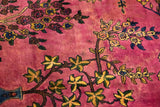 Subtle color variations in the cochineal red field of a hand-knotted vintage carpet.