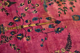 Close-up of floral sprays and vine motifs on a rich magenta field showing time-softened haloeing.