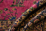 A folded view of the vintage Meshed carpet highlights its plush pile and rich floral design.