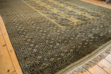 Angled view of an Ersari carpet highlighting its thick wool pile and rich sheen on the camel and navy design.