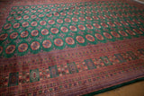 Vintage Bokhara carpet's corner with intricate geometric borders in rust, emerald green, and navy.