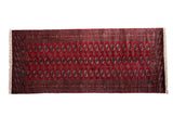 Fine vintage Bokhara runner with repeating gul medallions set in columns on a deep cherry red field.