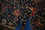 Close view of the hand-knotted carpet's navy field with red and gold tree of life motifs.