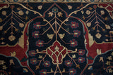 Close-up of the vintage carpet's turtle Samovar design in red and gold on a lush navy blue pile.