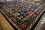 Angled view of a vintage carpet corner, showing the dragon-inspired border and navy floral field.