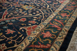 Close view of a vintage carpet's dragon-inspired border and navy blue tree of life field motifs.