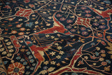 Detailed floral arabesques and branching vines in brick red and ivory across the plush navy pile.