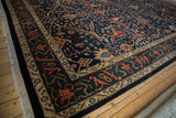 Corner perspective on a vintage Indian carpet highlighting the dragon-motif border and dense navy field.