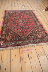 Fringed lower edge, dark brown geometric border, and playful motifs of a vintage Abadeh rug.
