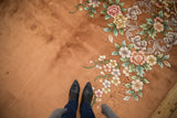 Vintage Art Deco rug with copper field, shallow carved floral motifs, and green vines.