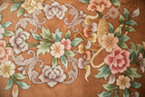 Art Deco carpet close-up: shadow embossed foliage and vines in blush, copper, and green.
